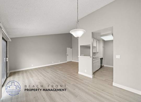 the spacious living room and kitchen of this renovated beachfront property