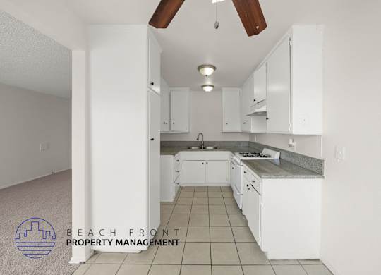 A kitchen with white cabinets and a tile floor.