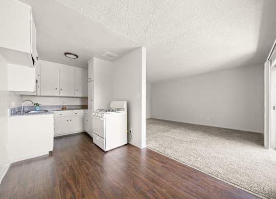 A white kitchen with a white fridge and a white baby crib.