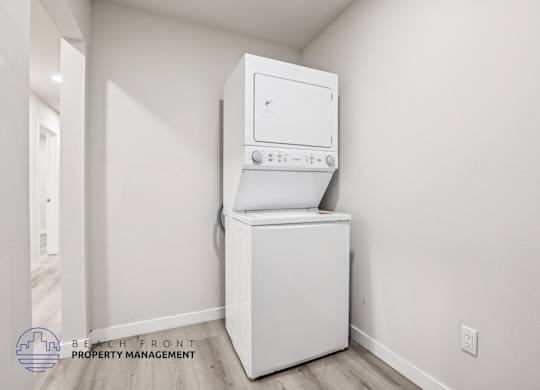 A white washing machine and dryer in a room with white walls.