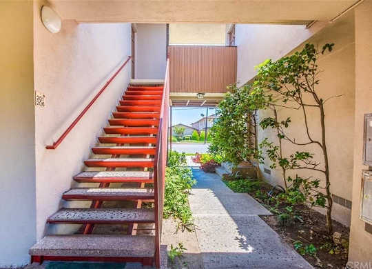A red staircase with a white wall on the side.