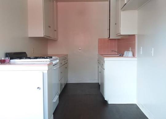 A kitchen with white cabinets and a black stove top oven.