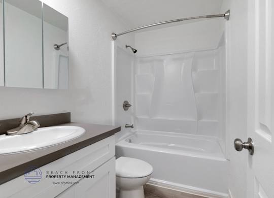 A white bathroom with a sink, toilet, and bathtub.