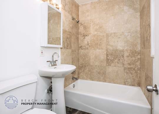 A bathroom with a white sink and bathtub.
