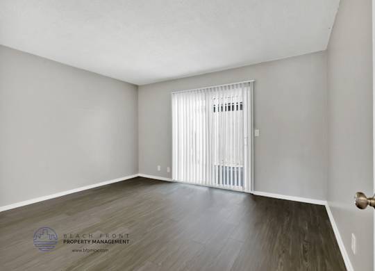 A room with a wooden floor and a white door.