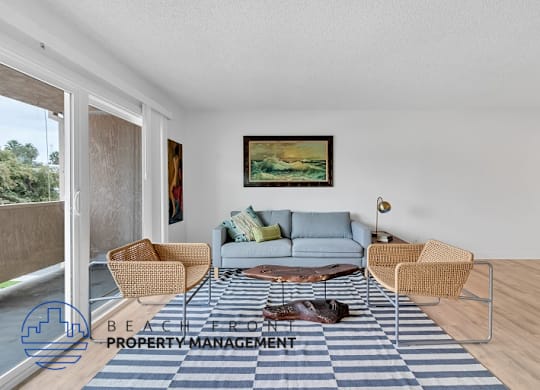 A living room with a blue couch, a painting on the wall, and a dog on the floor.