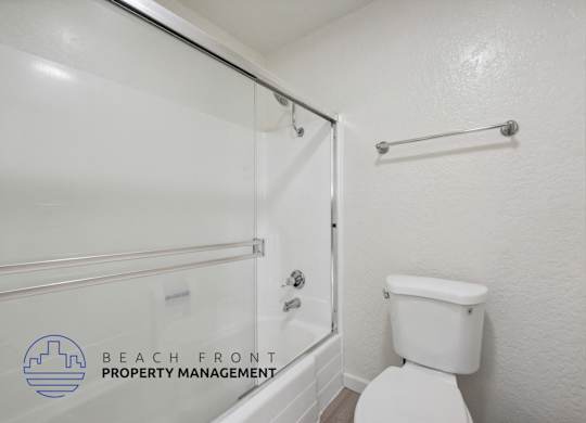 A white toilet in a bathroom with a glass shower door.