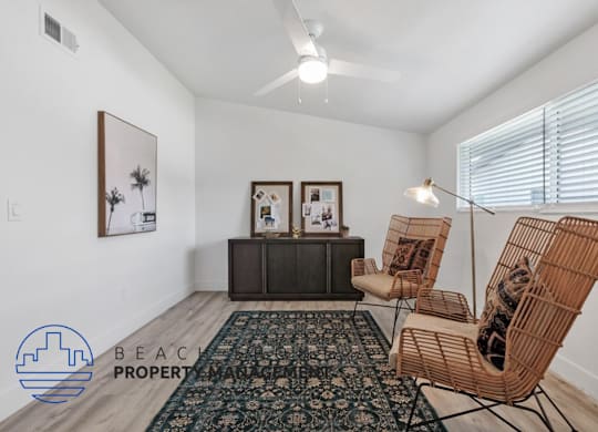 a living room with two chairs and a cat in a rocking chair