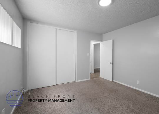 a master bedroom with white closets and a carpeted floor