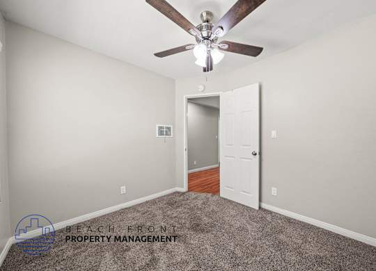 A room with a ceiling fan and a carpeted floor.