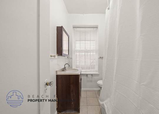 A small bathroom with a toilet, sink, and window.