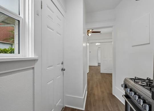 A white hallway with a stove on the right.