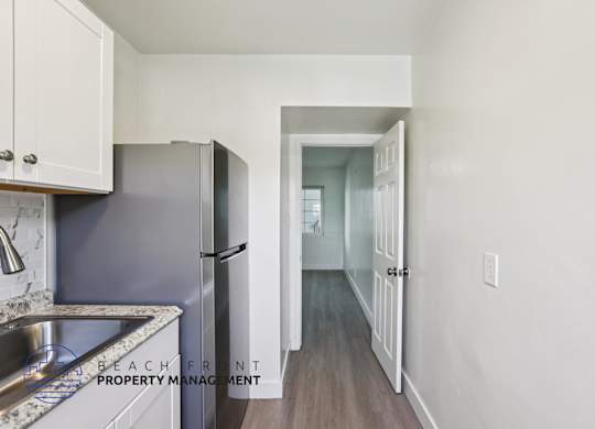 A kitchen with a sink and a refrigerator.