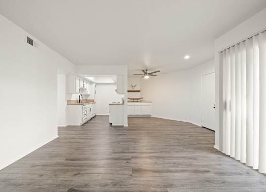 A spacious kitchen with a fan and a dining table.