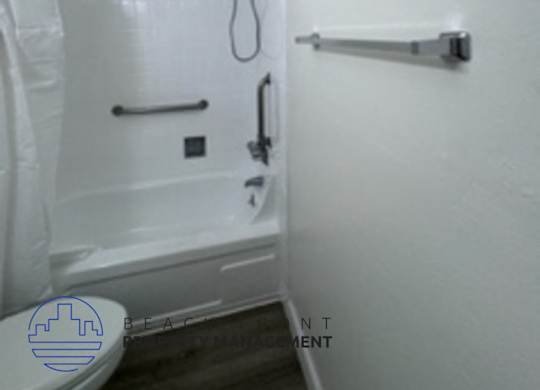 A white bathroom with a toilet and a shower.