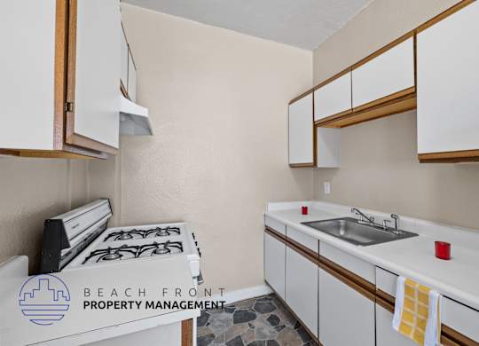 A kitchen with white cabinets and a stove top oven.