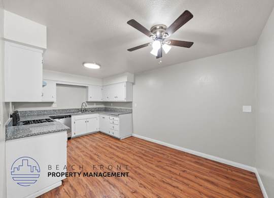 A room with a ceiling fan and wooden flooring.