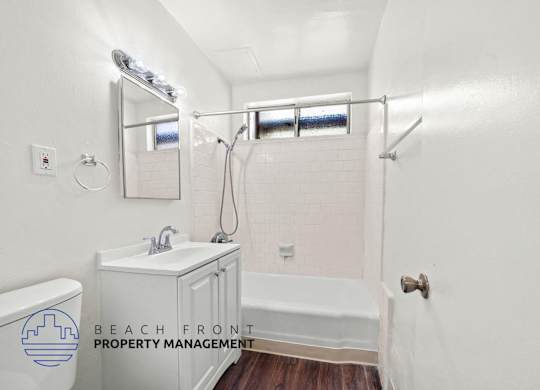 A white bathroom with a toilet, sink, and bathtub.