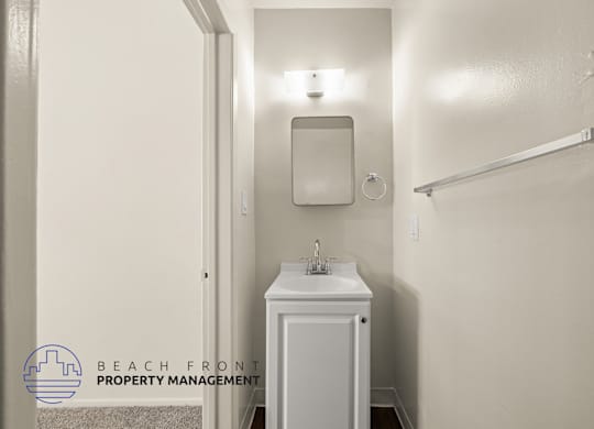A small white bathroom with a sink and mirror.