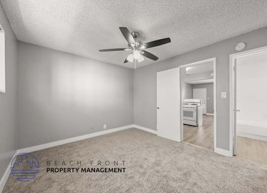 A room with a ceiling fan and a carpeted floor.