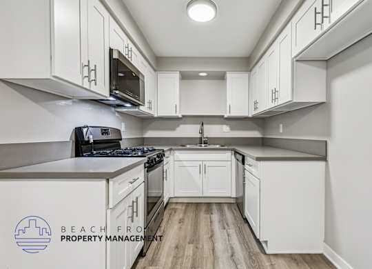 A kitchen with white cabinets and a stove top oven.