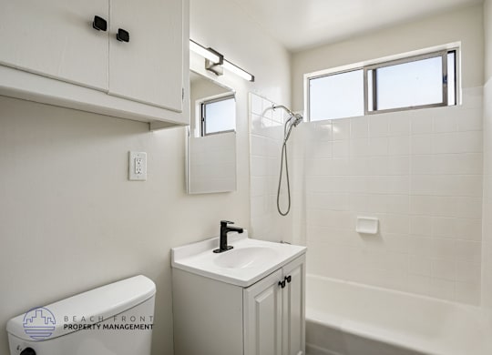 A white bathroom with a toilet, sink, and bathtub.