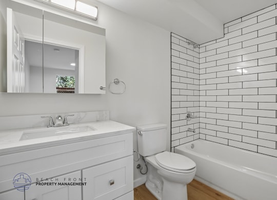 A white bathroom with a sink, toilet, and bathtub.