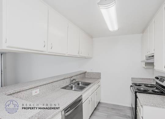 A kitchen with white cabinets and a granite countertop.