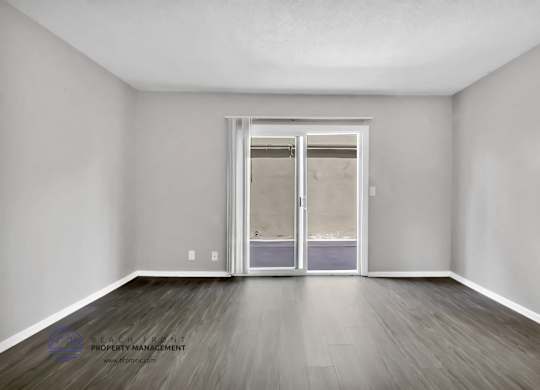 A room with a sliding door and wooden flooring.