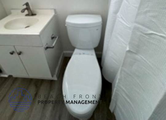 A white toilet sits next to a sink in a small bathroom.