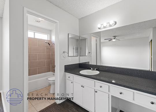 a bathroom with white cabinets and a sink and a mirror