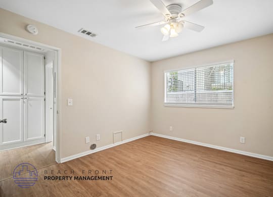 A room with a ceiling fan and a window with blinds.