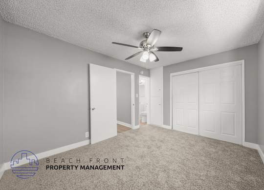 A room with a ceiling fan and a carpeted floor.