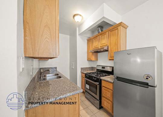 A kitchen with a granite counter top and stainless steel appliances.