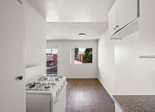 A kitchen with a stove and a window.