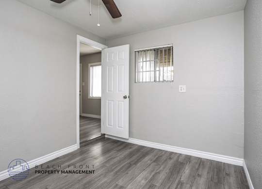 A room with a door and a window with blinds.