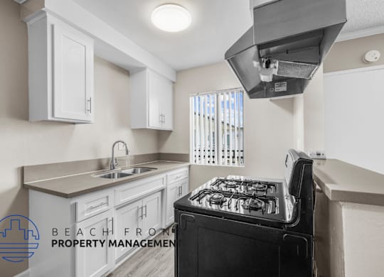 a kitchen with white cabinets and a stove and a sink
