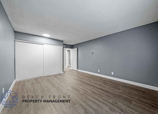 A room with wooden flooring and a sliding door.