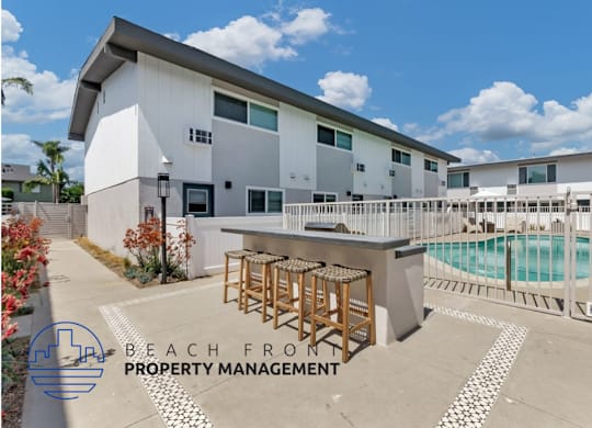 a patio with a bar and a pool in front of a building