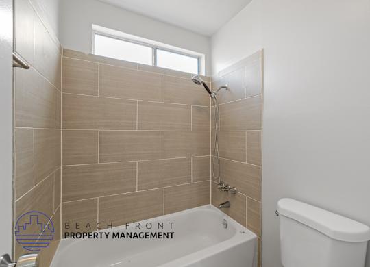a bathroom with a tub and a toilet and a window