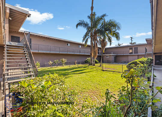 A sunny day at a residential complex with a palm tree in the foreground.