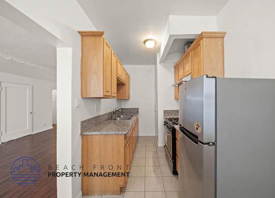 A kitchen with wooden cabinets and a stainless steel refrigerator.