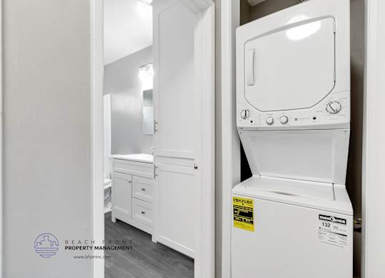 A white dishwasher is in a kitchen with a sticker on it.