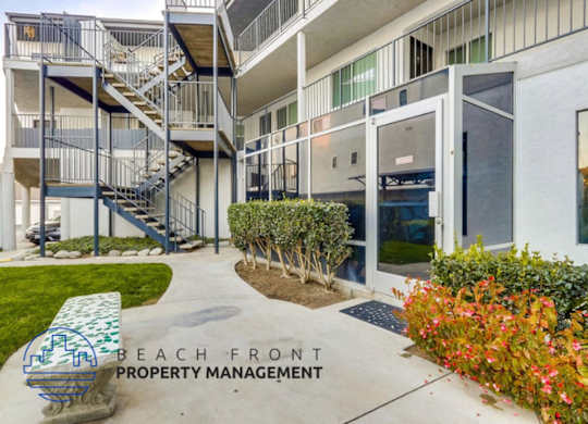 a view of the entrance to a beach front property management building with stairs and plants