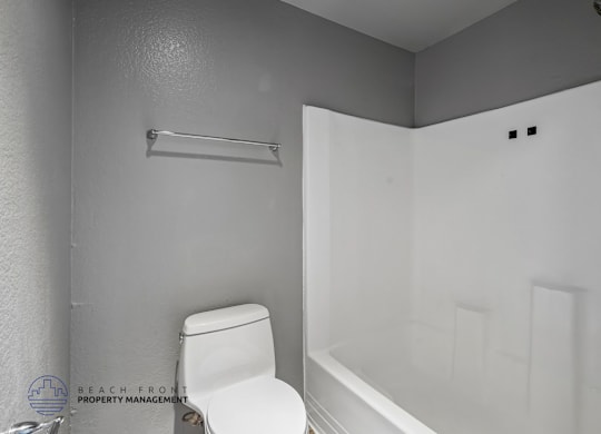 A white toilet is next to a white bathtub in a bathroom.