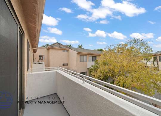 a balcony with a view of a building and a tree