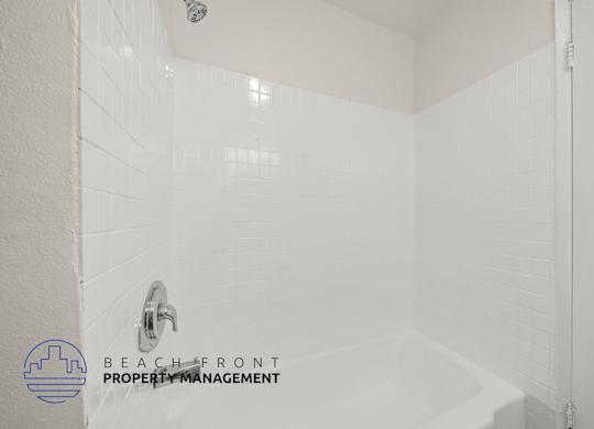A white bathroom with a shower and a faucet.