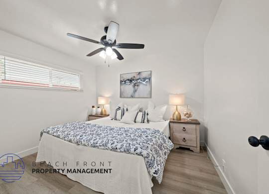 A bedroom with a bed, nightstands, and a ceiling fan.