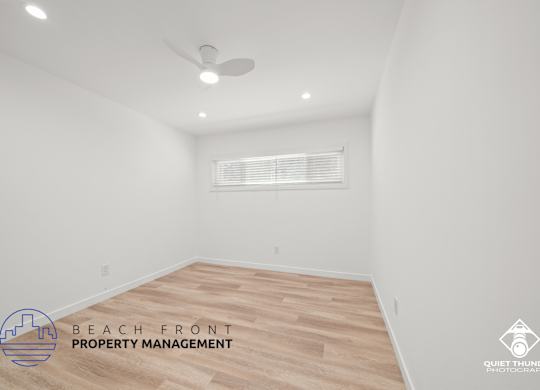 a white room with a wood floor and a ceiling fan