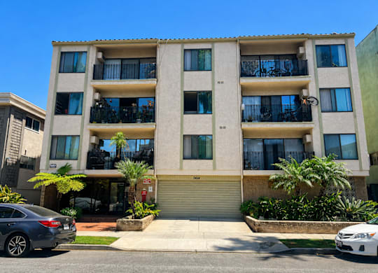 A modern apartment building with a car parked in front.